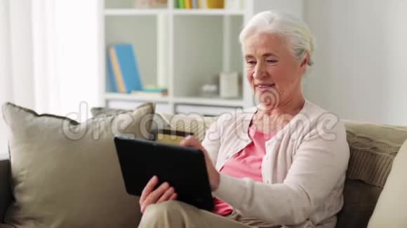 有平板电脑和信用卡的老年妇女视频的预览图