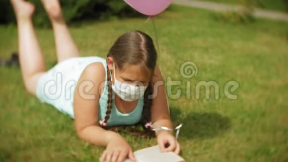 戴防毒面具的可爱女孩在公园看书视频的预览图