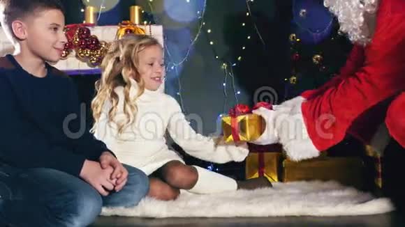 圣诞老人和孩子们围着装饰好的圣诞树视频的预览图