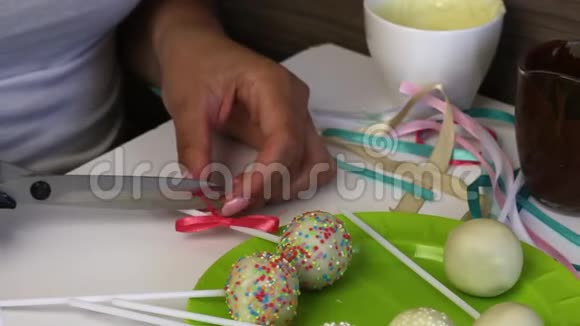 一个女人在盘子里装饰辫子蛋糕的蝴蝶结视频的预览图