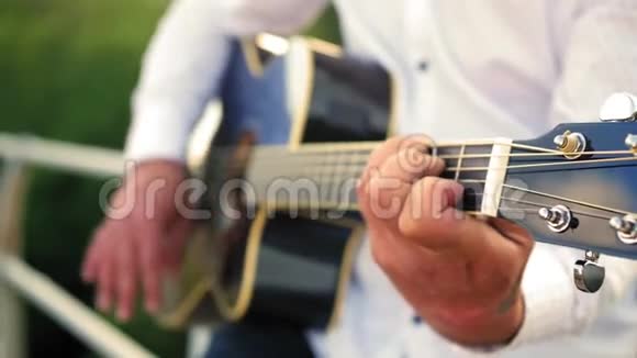 男人弹吉他吉他手在触摸吉他弦近距离射击视频的预览图