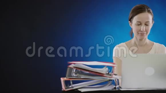 微笑的女人在笔记本电脑上打字视频的预览图