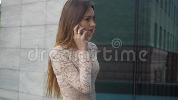 美丽的年轻女子在户外讲手机视频的预览图