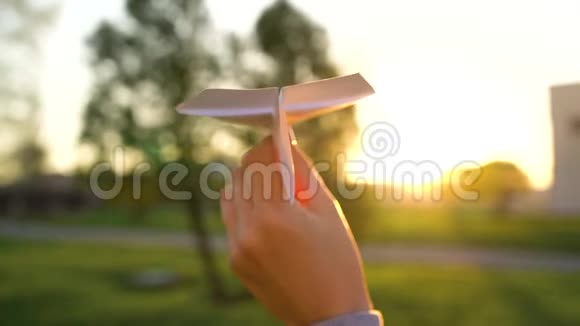 手发射纸飞机在日落背景下慢动作视频的预览图