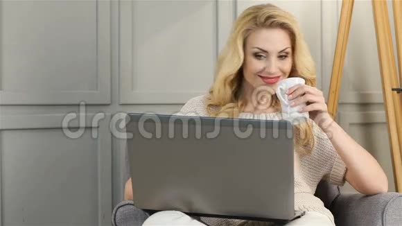 迷人的微笑女人在笔记本电脑上工作视频的预览图