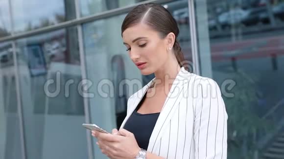 漂亮的商务女性在户外办公室附近打电话视频的预览图