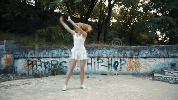 年轻的亚洲女人在城市公园外面跳现代舞蹈城市废墟和涂鸦视频的预览图