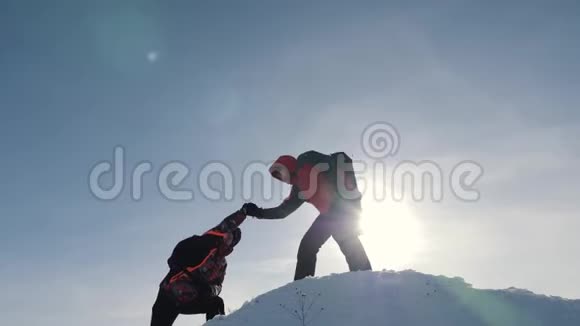 游客团队合作爬山互相帮助到达山顶克服困难伸出援助之手视频的预览图