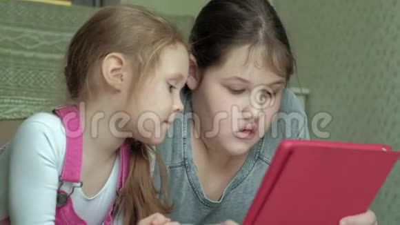 女孩们姐妹在房间里玩平板电脑上网休息视频的预览图