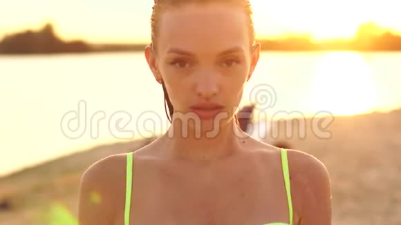 日落时穿泳衣的年轻女士视频的预览图