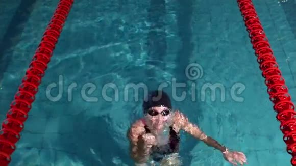 合适的女人在游泳池里举起手臂视频的预览图