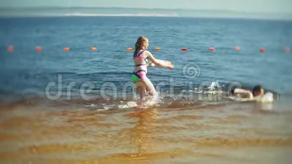 快乐的孩子们正在跳入大海的浪花里视频的预览图