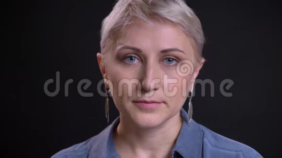 一张美丽的白种人女性脸的特写肖像直视镜头背景与黑色隔离视频的预览图