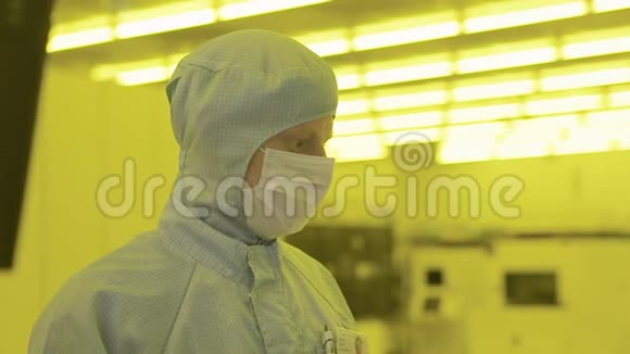 穿无菌服的工程师科学家面具在清洁区里看一个工艺技术先进的工厂视频的预览图