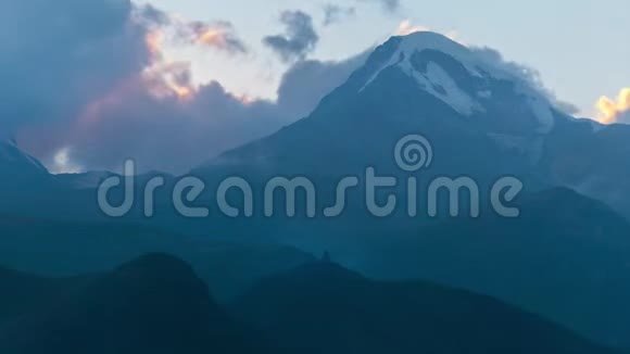 神秘的高山景观卡兹别克山上白雪皑皑的山峰峡谷山顶上的教堂视频的预览图