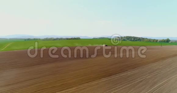 拖拉机在美丽宽敞的农田里作业视频的预览图