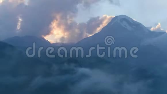 高山高原的薄雾黄昏浓雾笼罩着喀斯别克山顶雪帽视频的预览图