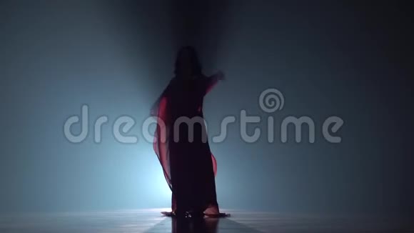 在黑烟背景下穿裙子跳舞的女孩西瓦特慢动作视频的预览图