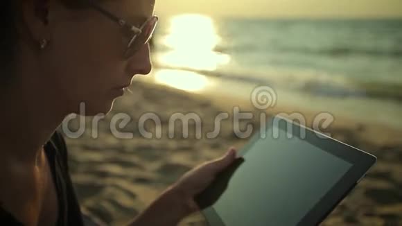 女人在海边使用平板电脑视频的预览图