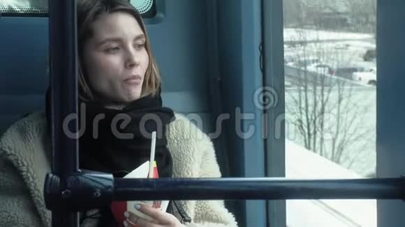 年轻的黑发女人乘坐公共交通工具带着耳机使用电话视频的预览图