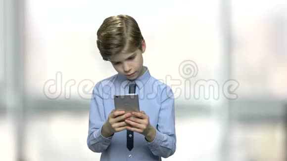 英俊的白种人男孩使用智能手机视频的预览图