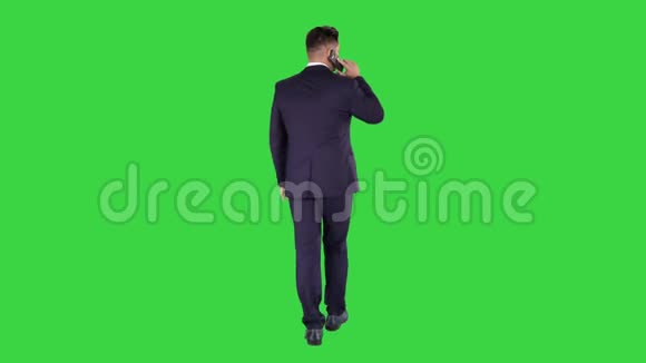 走路的商人用手机在绿色屏幕上说话铬钥匙视频的预览图