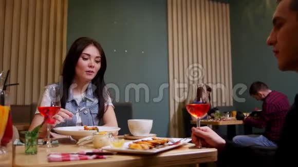 一对年轻夫妇坐在咖啡馆的桌子旁视频的预览图
