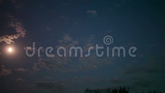 夜空中的满月明亮的月亮夜空在夜空中的云的运动背景下视频的预览图