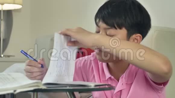 亚洲可爱的男孩在家用笔记本电脑做作业视频的预览图