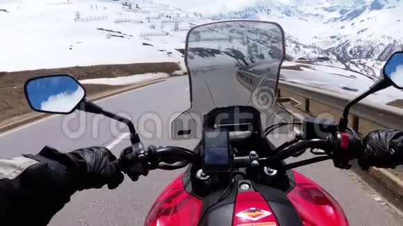摩托车手骑在瑞士阿尔卑斯山附近美丽的风景雪山公路上瑞士视频的预览图