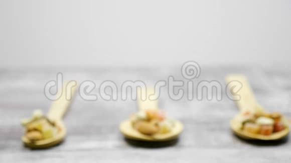 不同类型的坚果和甜的木制勺子视频的预览图