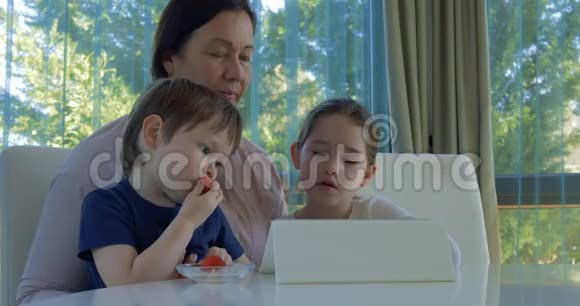 奶奶用平板电脑游戏招待她的小孙子们视频的预览图
