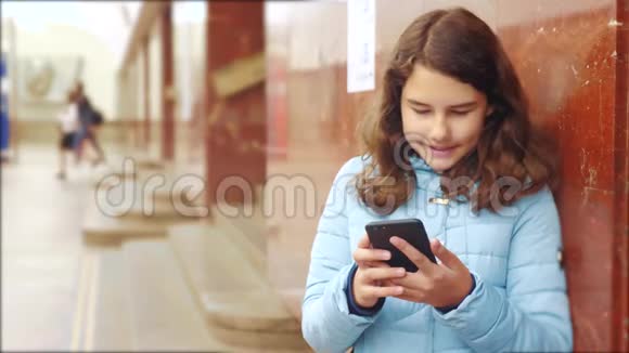 十几岁的女孩在地铁里坐地铁等着火车的到来生活方式持有智能手机视频的预览图
