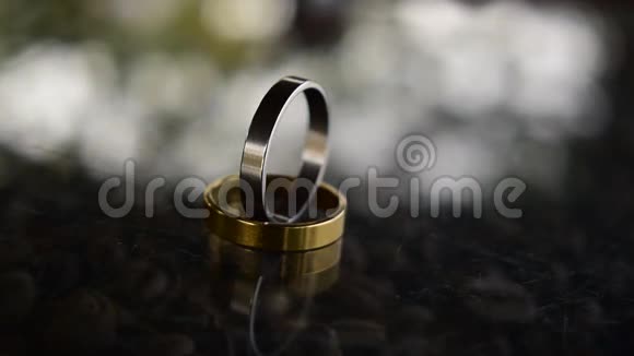 两个结婚戒指豪华的金银在木地板上视频的预览图