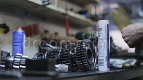汽车修理工修理车库内的传动机构视频的预览图