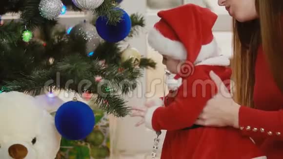 妈妈带着孩子在圣诞树旁视频的预览图