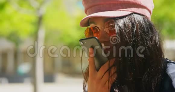 在城里用手机说话的年轻女子视频的预览图