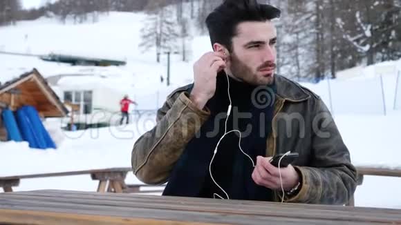 在雪地里拿智能手机的年轻人视频的预览图