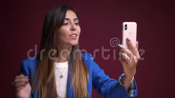 一位年轻有魅力的高加索女性的特写照片她在电话里打了个视频电话视频的预览图