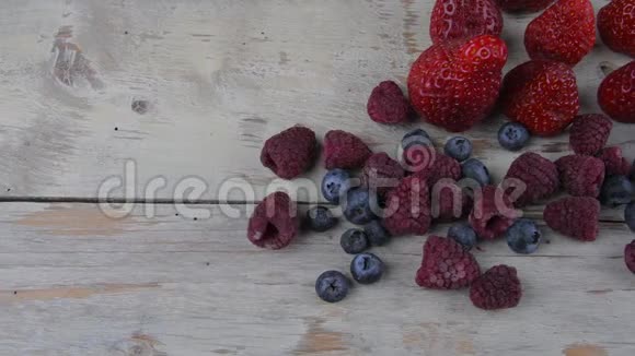 健康混合水果和配料草莓覆盆子蓝莓浅白色木制背景浆果视频的预览图
