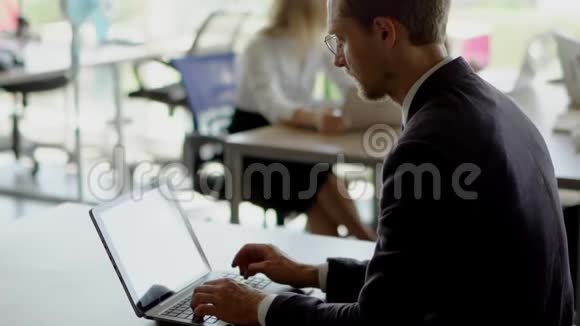 穿西装的帅哥在笔记本电脑上工作视频的预览图