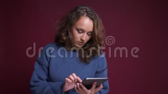 用平板电脑拍摄白种人年轻女性的特写肖像微笑着用绿色屏幕拍摄视频的预览图