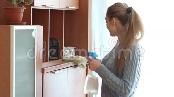 幸福家庭主妇用喷雾器清洁橱柜视频的预览图