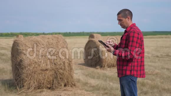 智慧农业理念男子工人农民在数字平板电脑上的生活方式领域研究干草堆慢慢慢慢视频的预览图