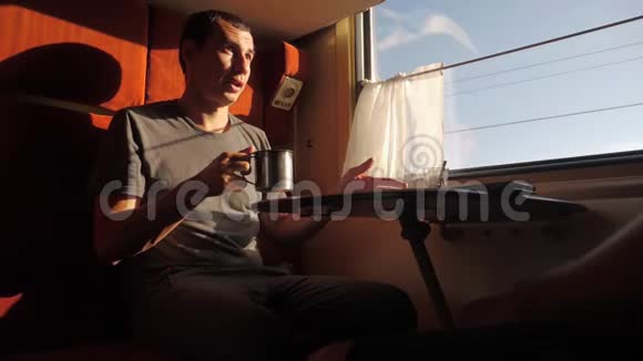 一个人坐在火车车厢的窗户上车在喝茶咖啡在说话视频的预览图