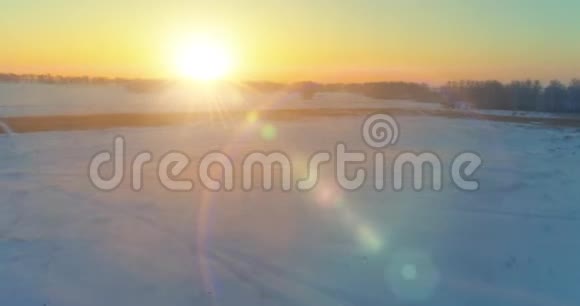 无人驾驶飞机观看寒冷的冬季景观北极的田野覆盖着霜雪的树木和清晨的阳光视频的预览图