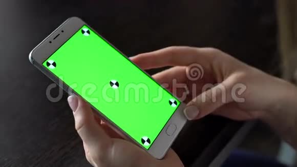 年轻女性使用带有绿色屏幕的智能手机进行交流视频的预览图