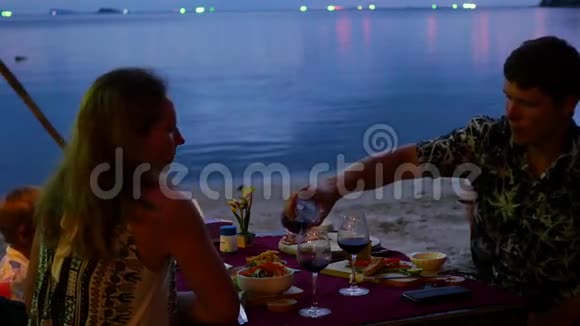 一家人在海滩上的餐馆吃饭视频的预览图