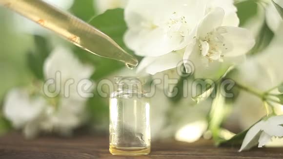 漂亮的玻璃罐子里木制背景上的花朵的精华视频的预览图