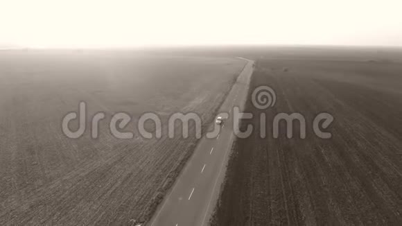 从无人驾驶飞机上看到田野中央的道路视频的预览图
